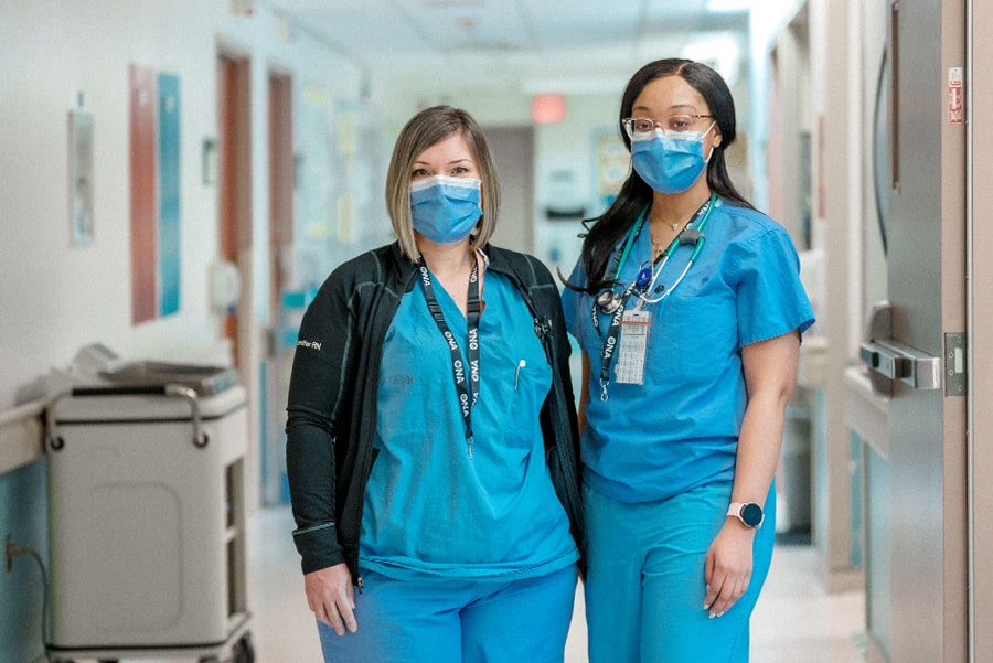 Two nurses standing in a hospital hallway